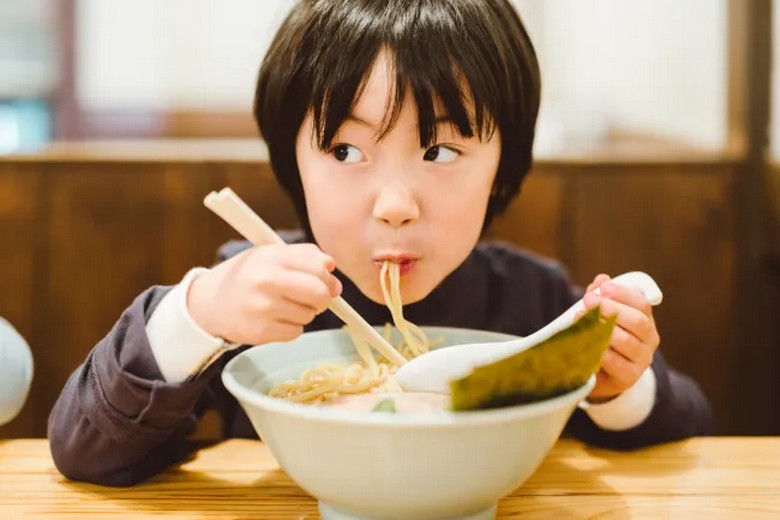 Em bé Việt ngồi ăn mì udon trong một nhà hàng gia đình ở Nhật