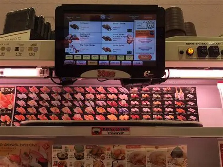 Màn hình cảm ứng gọi món sushi có hình ảnh và tiếng Anh tại quán băng chuyền