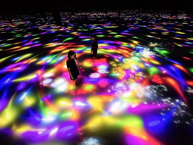 Trẻ nhỏ đi chân trần lội nước trong không gian ánh sáng ở teamLab Planets Tokyo