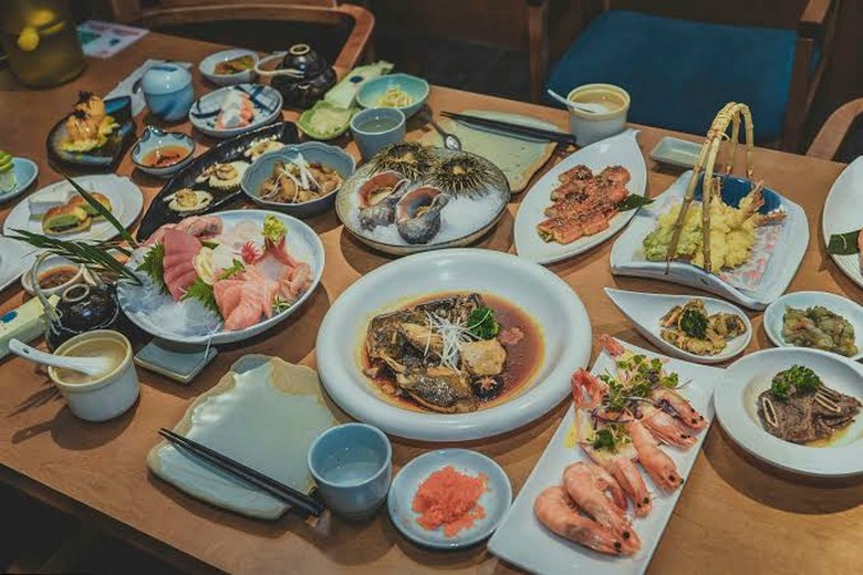 Bàn ăn set trong tour với nhiều món Nhật bày sẵn cho cả đoàn