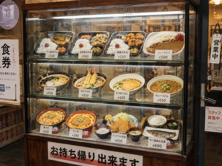 Tủ kính trưng bày các suất cơm và mì có ghi giá ở một quán ăn Tokyo
