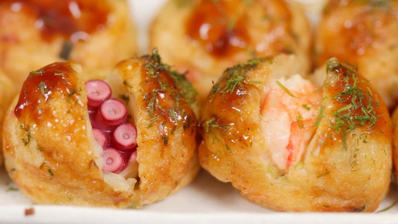 Cận cảnh bên trong viên takoyaki với miếng bạch tuộc, vỏ giòn ngoài mềm trong